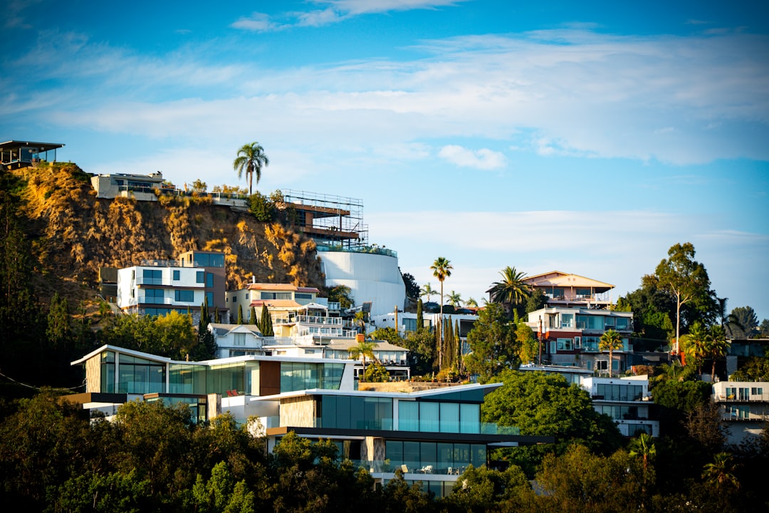 Modern homes nestled on a hillside with trees.