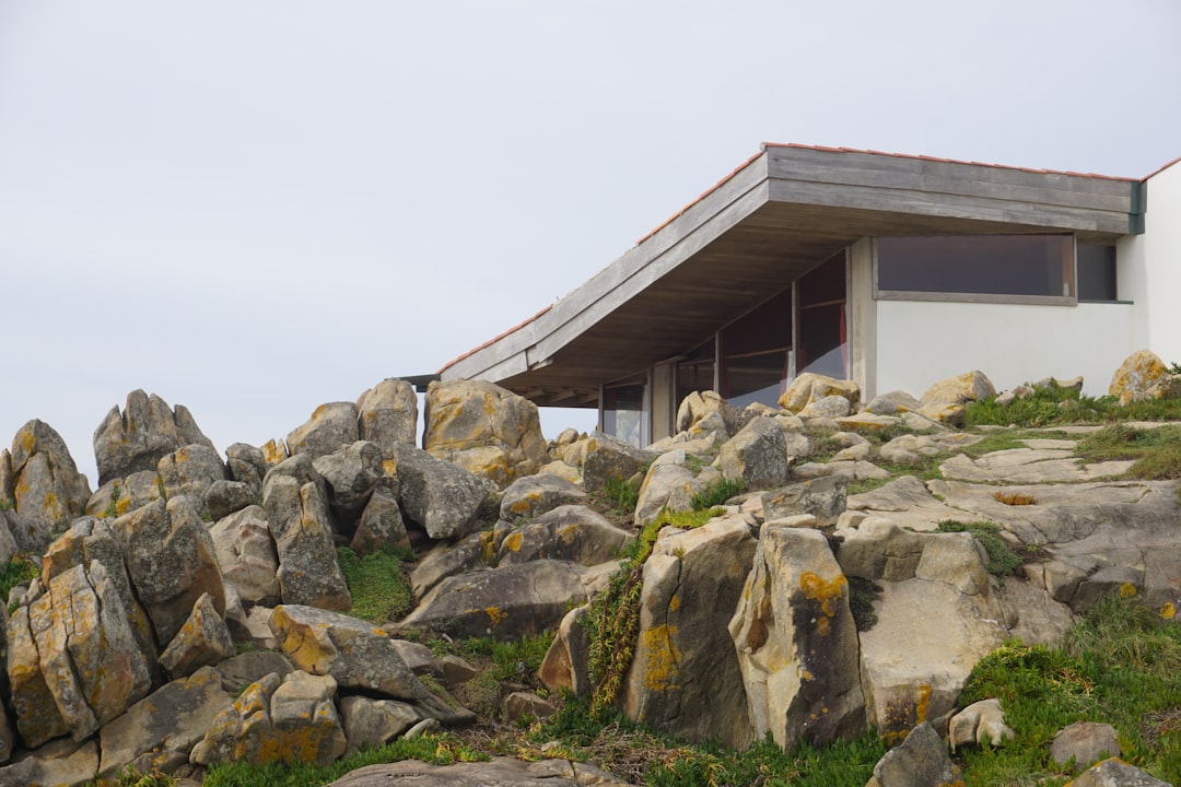 Modern building sits atop rocky terrain.